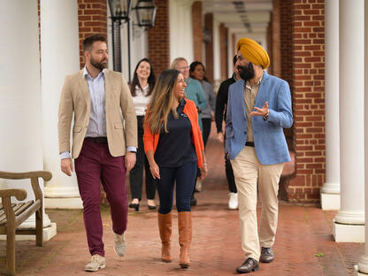 Several students and alumni walking and talking on Darden Grounds