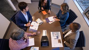 exec mba students at conference table with notes