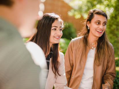 two female students outside laughing