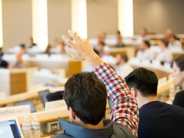student raising a hand during class