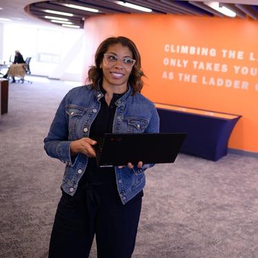 woman standing in uva darden dc metro with an open computer